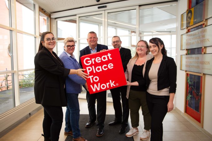 KHWE Mitarbeiterinnen und Mitarbeiter halten einen Würfel mit dem Great place to work-Logo  | © KHWE