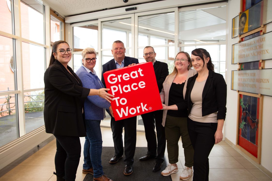 Wir sind ein Great Place to Work | © KHWE KHWE Mitarbeiterinnen und Mitarbeiter halten einen Würfel mit dem Great place to work-Logo | © KHWE